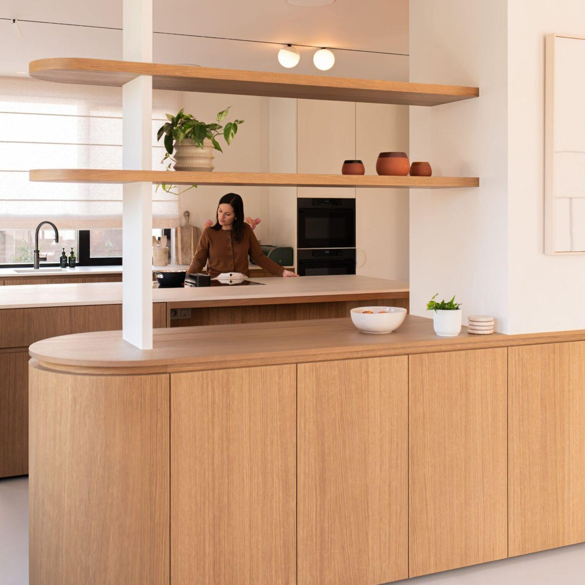 A women standing beside custom kitchen cabinets
